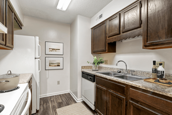 A kitchen with dark wood cabinets and white appliances